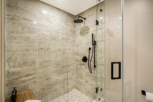 a bathroom with a shower with a glass door at Kindred Resort, A RockResort in Keystone