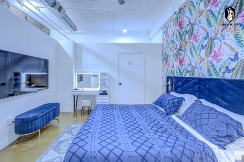 a bedroom with a blue bed and a desk at The Stallion #101 - 1BD Modern Loft with Private Patio - Walk to various attractions in Memphis