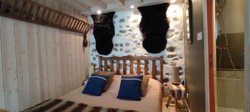 a bedroom with a bed with blue pillows and a wall at La Fleur de Lys in Moulins