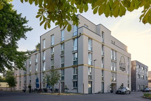a large white building on a street at Boutique Hotel Zuckerfabrik Stuttgart in Stuttgart
