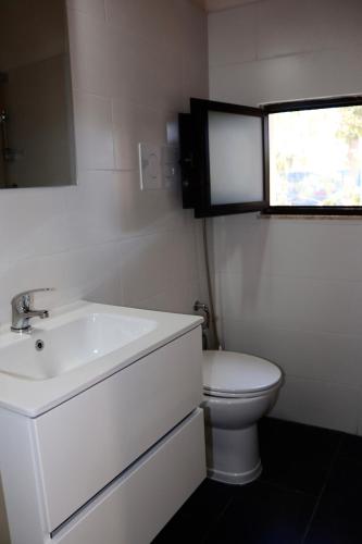 a white bathroom with a sink and a toilet at Pantera Rosa Village in Scalea
