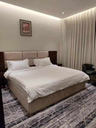 a bedroom with a large bed with white sheets at فندق نوفا ستاي in Nughaylah