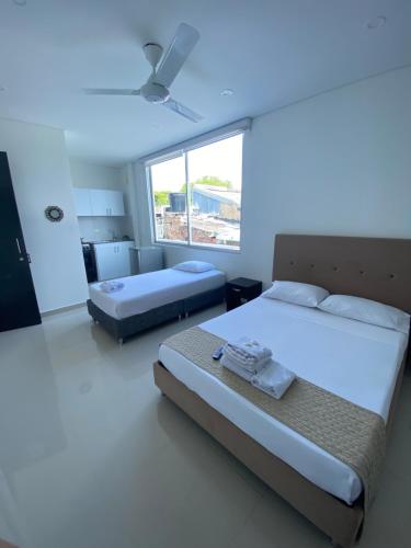 a bedroom with two beds and a large window at CasaBlanca ApartaEstudios in Girardot