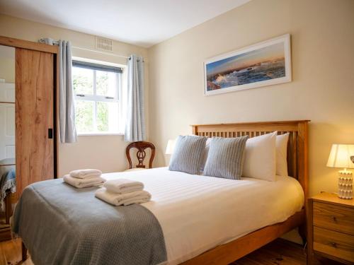 a bedroom with a bed with towels on it at Central Dingle Cottage in Dingle
