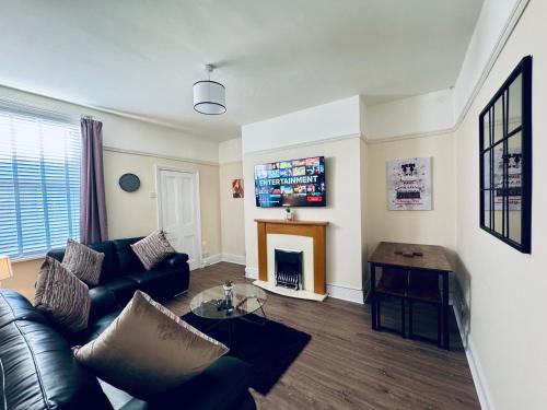 a living room with a couch and a fireplace at Park Apartment 2, Close to Tynemouth in Tynemouth