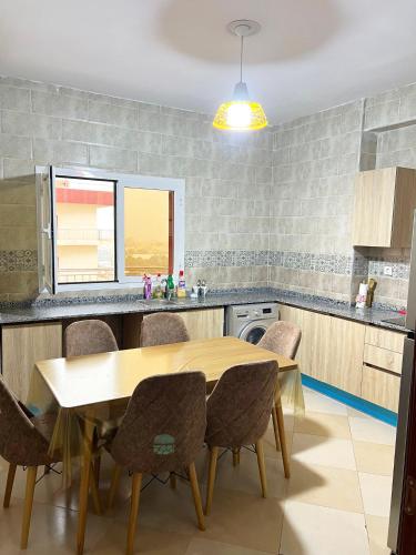 a kitchen with a wooden table and chairs at Le balcon bleu in Oran