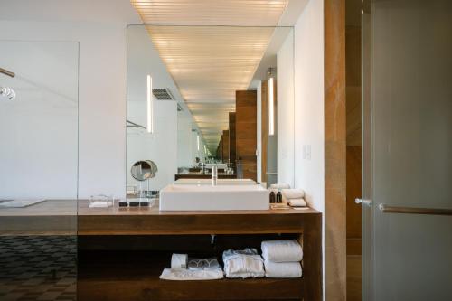 a bathroom with a sink and a large mirror at La Purificadora, Puebla, a Member of Design Hotels in Puebla