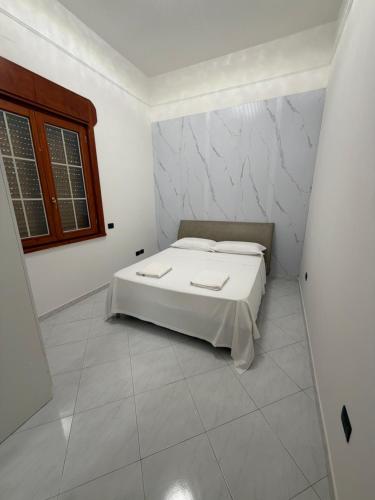 a white bedroom with a bed in a room at Vittoria & Celeste in Cervino