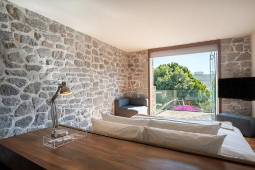 two beds in a room with a stone wall at La Purificadora, Puebla, a Member of Design Hotels in Puebla