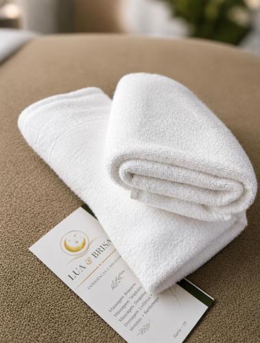 a towel sitting on top of a table with a card at Maré alta in Guriú
