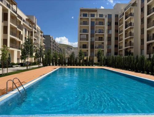 a large swimming pool in front of some apartment buildings at Чарвак Дарвозаси in Chorwoq