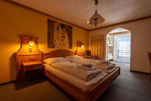 a bedroom with two beds and a large window at ALPEN ARNIKA Hotel & Restaurant in Tauplitzalm