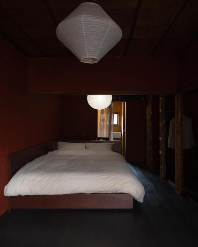a bedroom with a large bed with a white blanket at 刷々 sassa in Osaka