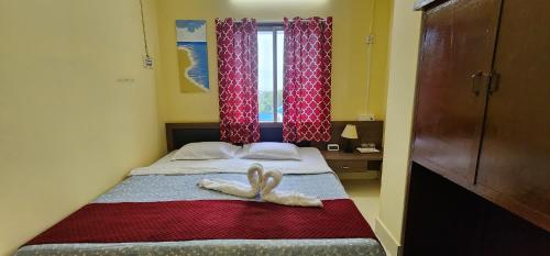 two swans are laying on a bed in a bedroom at Hotel Roy's in Shādipur