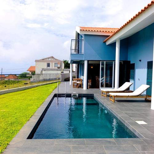 a swimming pool in the backyard of a house at Sunset Cottage - Special Places in Ponta do Pargo