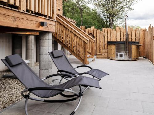 two chairs sitting on a patio with a wood fence at Romantikchalet Bärenhöhle mit eigenen Wellnessbereich, Komfort und viel Ruhe in Vorra