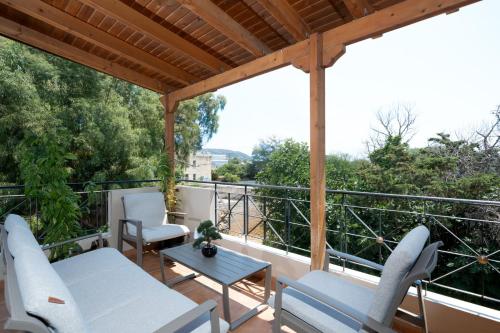 a balcony with chairs and a table and a view at Naria Home by A&D Properties in Porto Rafti