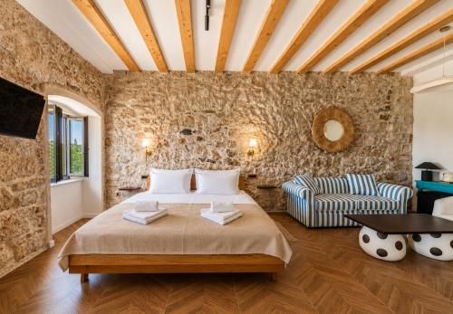 a bedroom with a large bed and a stone wall at Hotel Heritage Casa Blanka in Makarska