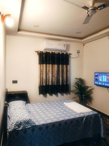a bedroom with a bed and a window with a tv at Farmview Guest House Netravali in Netorlim