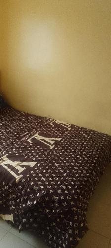 a bed with a black and white pattern on it at Elegance hotel in Ijaiye