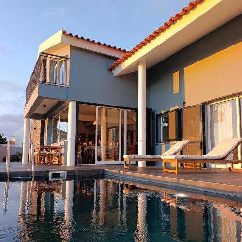 a house with a swimming pool in front of it at Sunset Cottage - Special Places in Ponta do Pargo