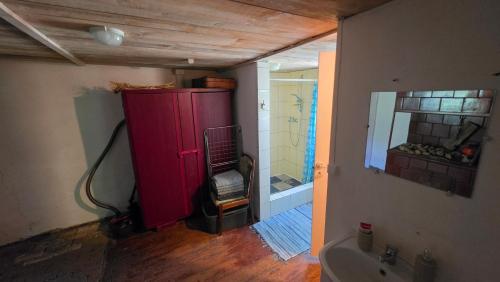 a bathroom with a red cabinet and a sink at Sena Troba in Druskininkai