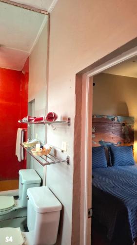 a bathroom with a bed and a toilet in a room at Suites Santo Domingo in San Miguel de Allende