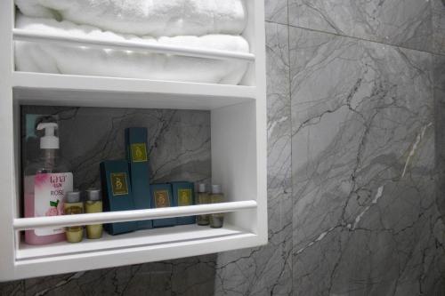 a bathroom cabinet with a shelf with products in it at Bralph-k in Yaoundé