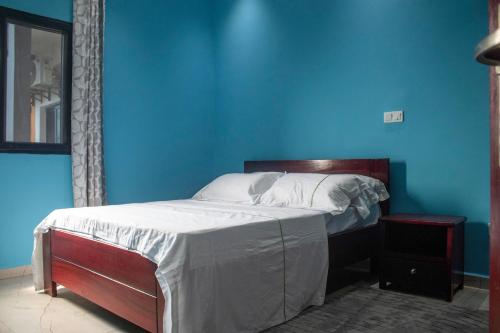 a blue bedroom with a bed in a room at Bralph-k in Yaoundé