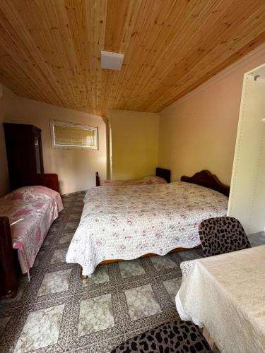 a bedroom with two beds and a wooden ceiling at Kobuleti Central in Kobuleti