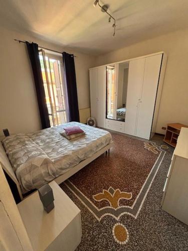 ein Schlafzimmer mit einem Bett und einem großen Fenster in der Unterkunft Corso Martiri in Cairo Montenotte