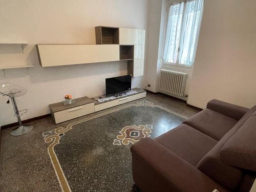 ein Wohnzimmer mit Sofa und Fernseher in der Unterkunft Corso Martiri in Cairo Montenotte