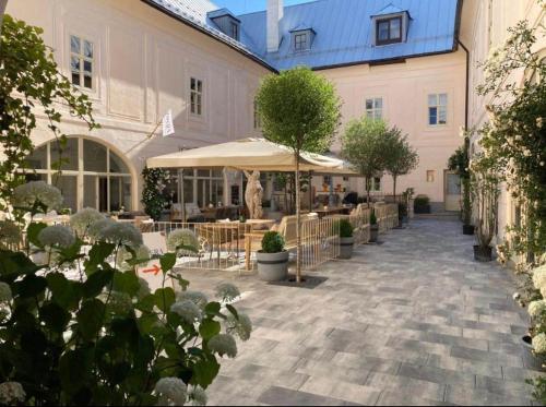 a courtyard with tables and umbrellas in front of a building at Opera apartmán -Banská Šťiavnica in Banská Štiavnica