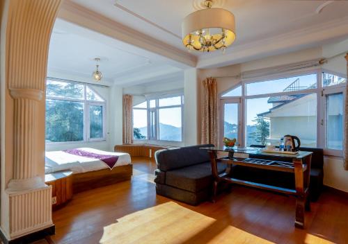 a living room with a bed and a desk at Hotel Windsor in Shimla