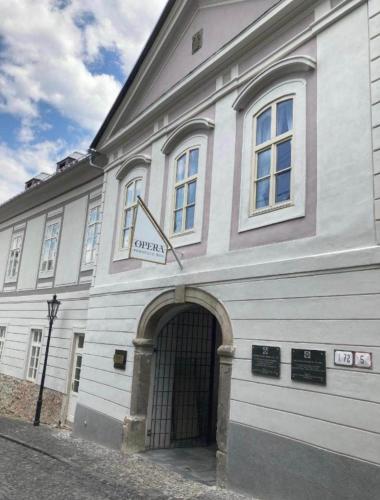 a white building with an archway in front of it at Opera apartmán -Banská Šťiavnica in Banská Štiavnica