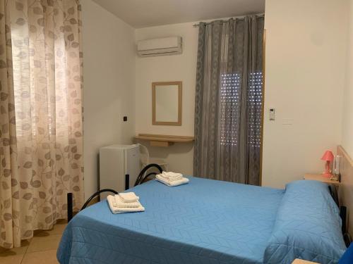 a bedroom with a blue bed with two towels on it at B&B Florida sul mare via faro 30 in Capo Rizzuto