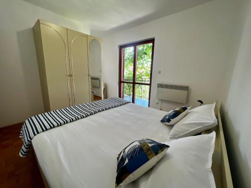 a bedroom with a large white bed with pillows on it at Vodice Center Apartments in Vodice