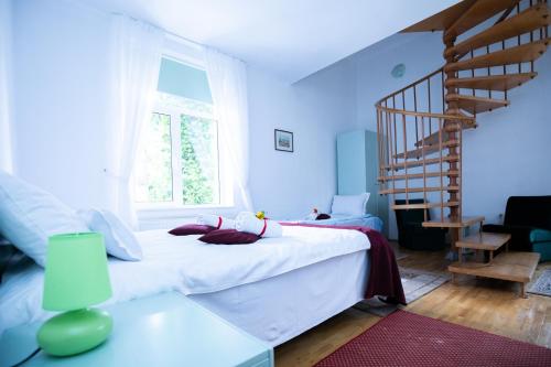 a bedroom with a white bed and a staircase at Clermont Sinaia in Sinaia