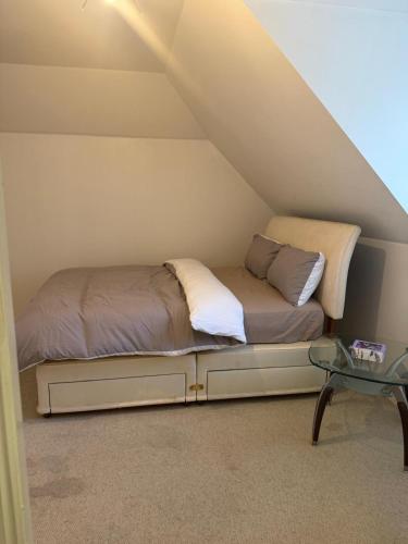 a bed sitting in the corner of a room at Cosy House in Reading