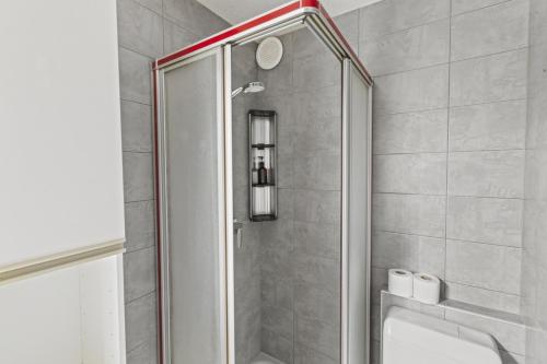 a shower with a glass door in a bathroom at Logement spacieux et charmant in Nendaz