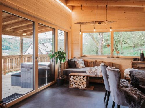 a living room with a bed and a large window at Romantikchalet Bärenhöhle mit eigenen Wellnessbereich, Komfort und viel Ruhe in Vorra