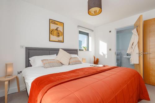 a bedroom with a large bed with an orange blanket at Silvermere in Warmwell