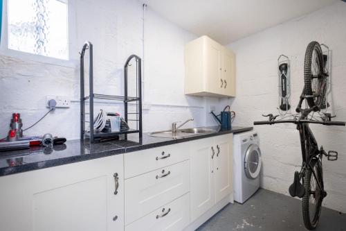 a kitchen with a sink and a washing machine at Ross Cottage in Hawkshead