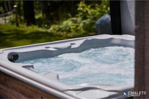a hot tub with water in a yard at Le Boreal in Pohénégamook