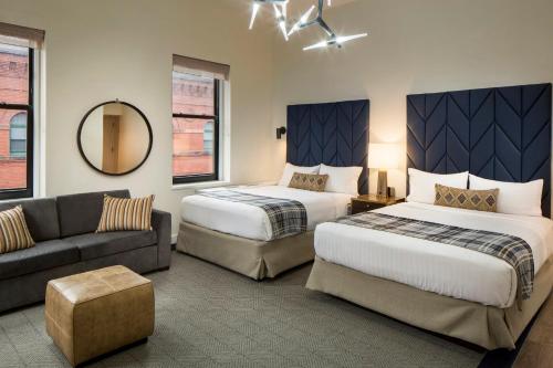 a hotel room with two beds and a couch at Hotel Indigo Boston Garden by IHG in Boston