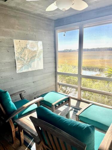 a room with a table and chairs and a large window at 1228 Creekwatch Villa in Seabrook Island