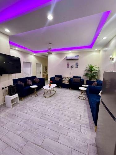 a living room with purple lights on the ceiling at شاليهات سكون الغروب in Taif