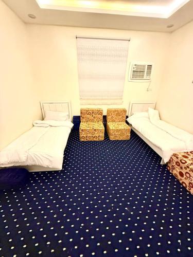 a room with two beds and a blue and white floor at شاليهات سكون الغروب in Taif