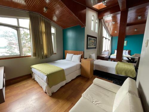 two beds in a room with blue walls and windows at Residencial Alfa Hotel in Lima