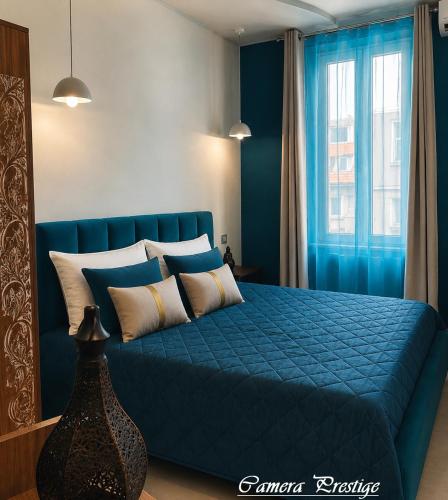 a bedroom with a blue bed with pillows at Dharma Luxury Room in La Spezia